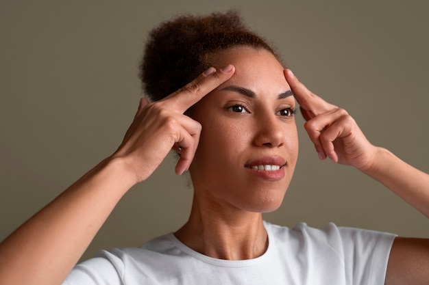 Free photo portrait of woman trying facial yoga massage to stay young