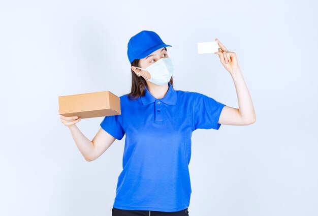 종이 상자를 들고 유니폼과 의료 마스크에 여자의 초상화