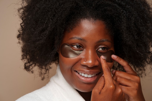 Free photo portrait of woman using eye patches for beauty