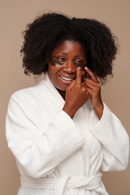 Free photo portrait of woman using eye patches for beauty