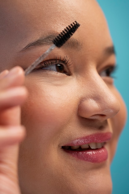 Free photo portrait of woman using eyebrow brush