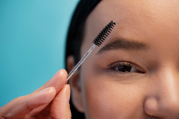 Free photo portrait of woman using eyebrow brush