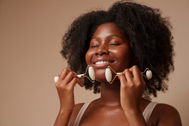 portrait of woman using face roller for beauty