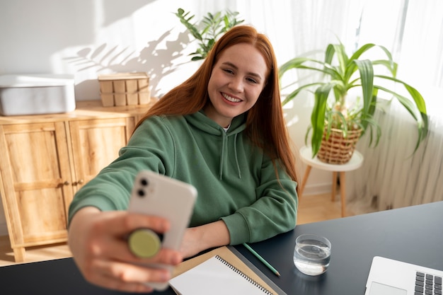 Free photo portrait of woman using smartphone with pop socket outdoors