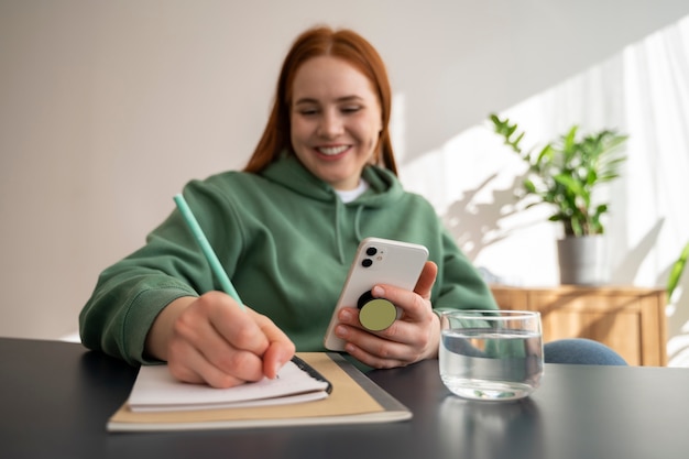 Portrait of woman using smartphone with pop socket outdoors