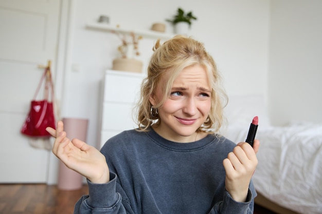 여성 블로거의 초상화 실망한 모습 립스틱을 보여주고 어깨를 끄덕여 녹음
