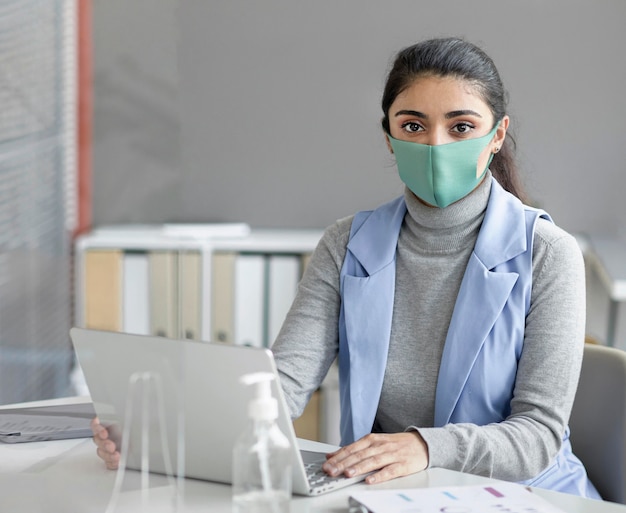 Ritratto di donna che indossa la maschera per il viso al lavoro