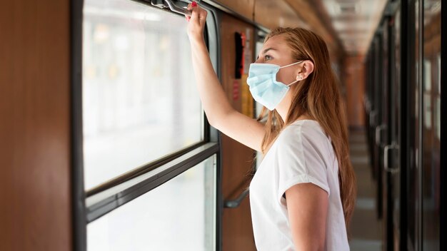 電車の中でマスクを着ている女性の肖像画