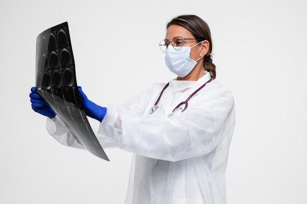 Free photo portrait of woman wearing medical gown and holding x-ray