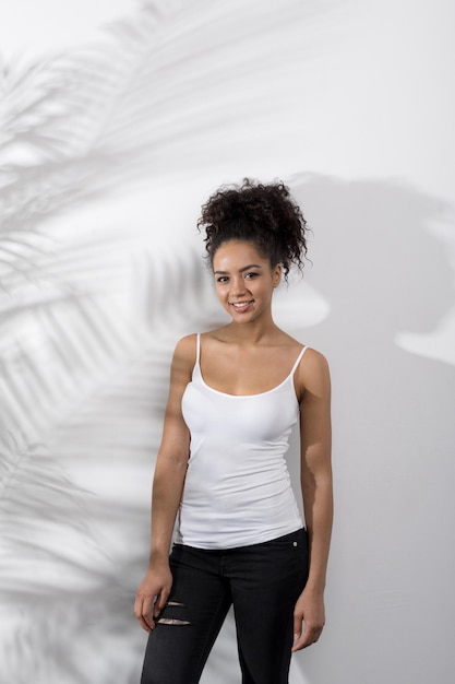 Free photo portrait of a woman wearing white tshirt standing at wall