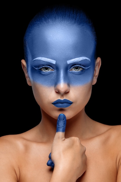 Portrait of a woman who is covered with blue paint