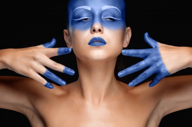 Free photo portrait of a woman who is posing covered with blue paint