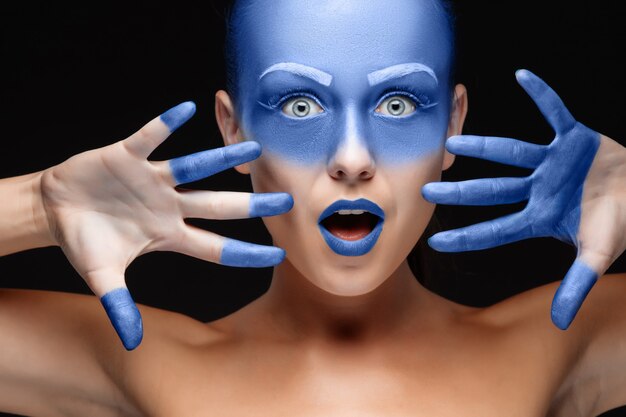포즈를 취하는 여자의 초상화는 파란색 페인트로 덮여