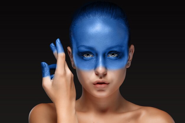 포즈를 취하는 여자의 초상화는 파란색 페인트로 덮여