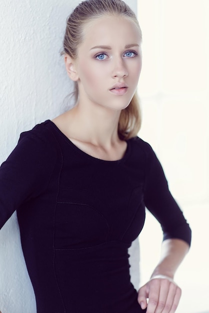 Portrait of a woman with blue eyes in black dress.