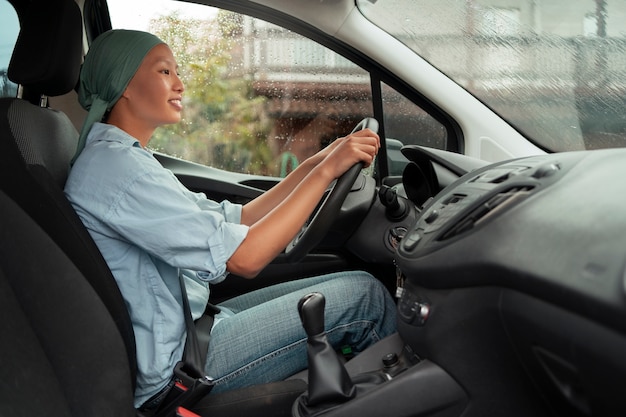 Portrait of woman with cancer driving car