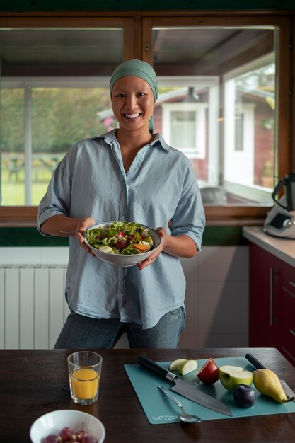 Portrait of woman with cancer eating salad at home