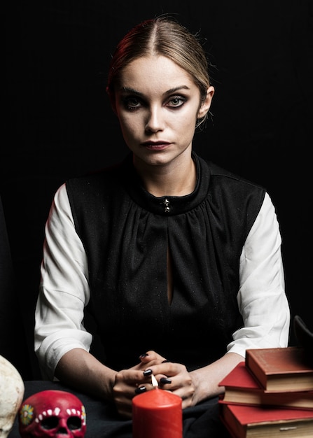 Free photo portrait of woman with candle and skull