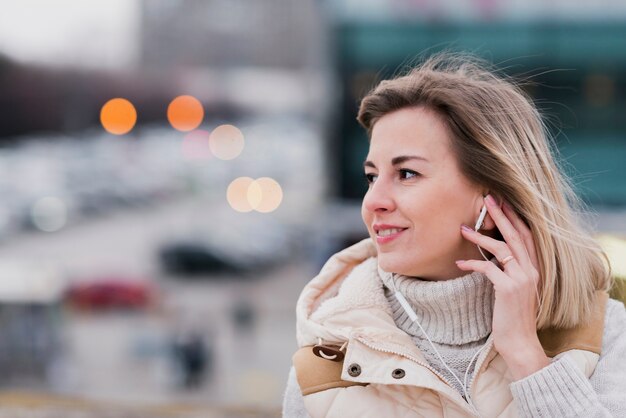 portrait of woman with earphones on roof