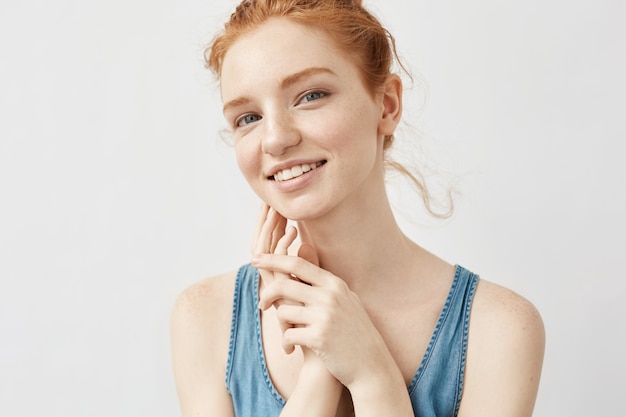 Портрет женщины с рыжими волосами позирует улыбается.