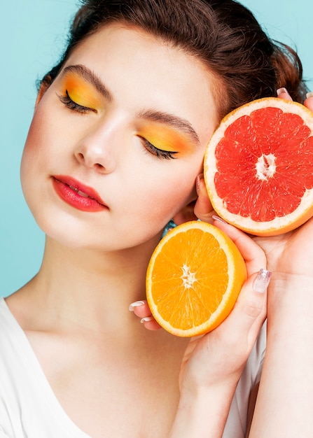 Foto gratuita ritratto di donna con pompelmo e arancia