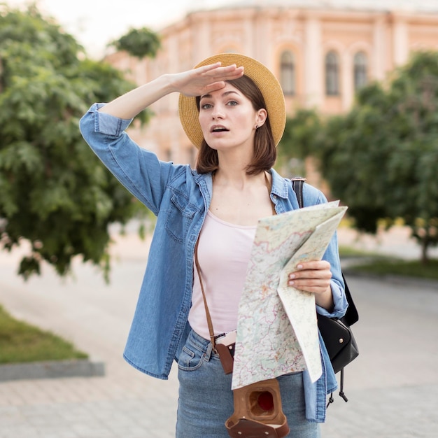 Foto gratuita ritratto di donna con cappello tenendo la mappa