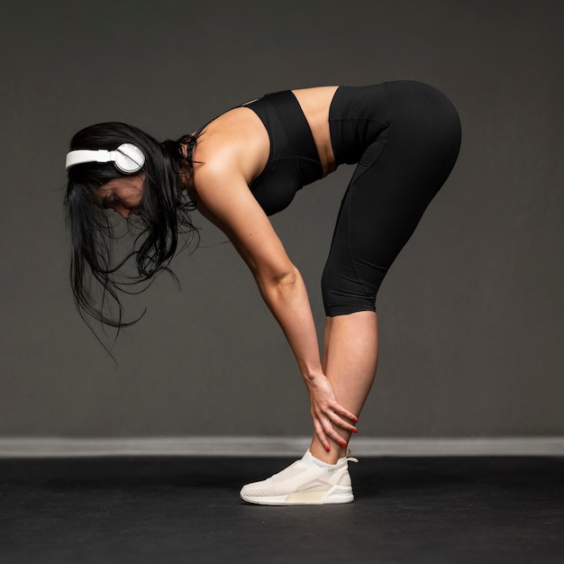 Portrait woman with headphones stretching