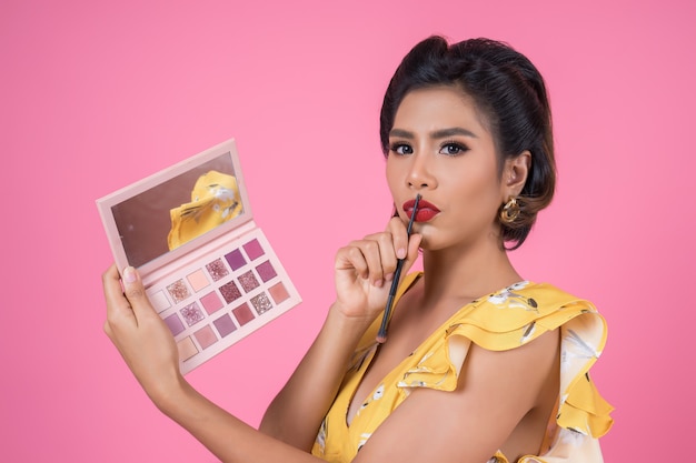 Portrait of woman with makeup brush and cosmetic 