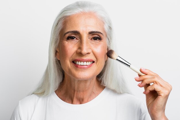 Free photo portrait of woman with makeup brush