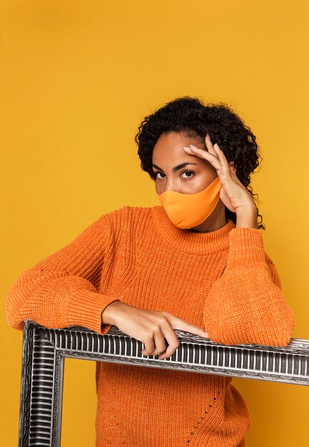 Portrait of woman with mask posing with frame