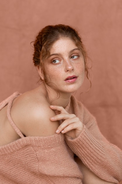 Free photo portrait of woman with pink sweater and naked shoulder