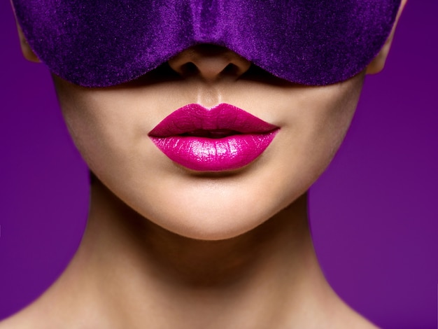 Free photo portrait of a woman with violet theatre mask on face and  purple lips