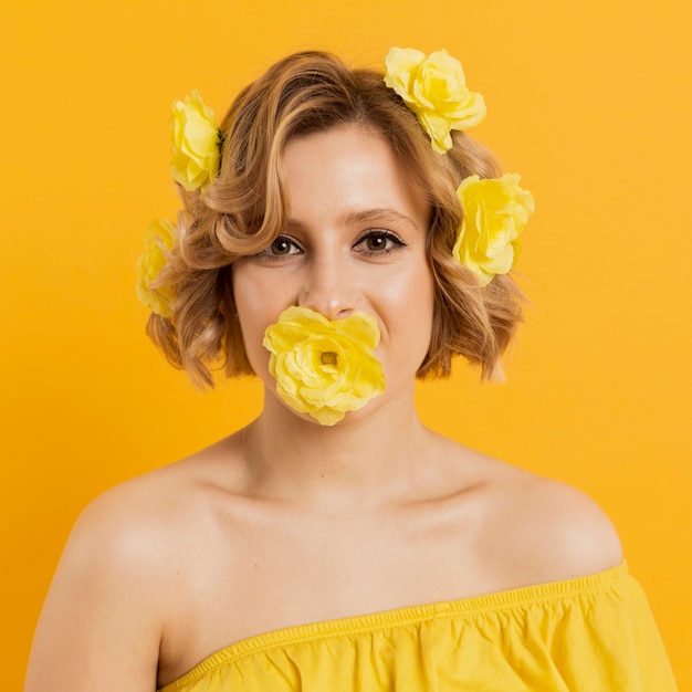 Free photo portrait woman with yellow flowers