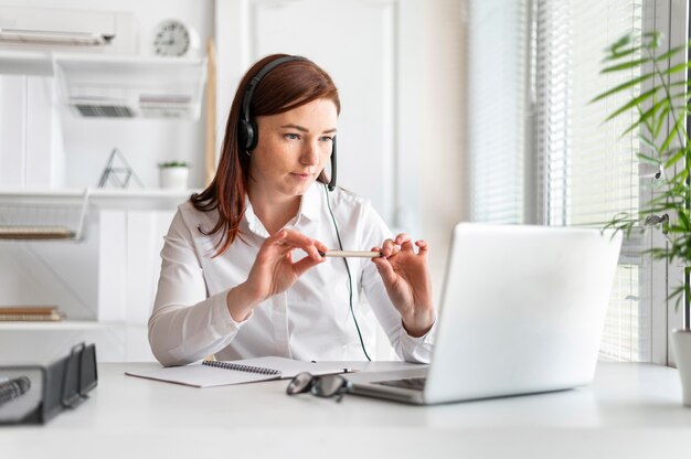 Портрет женщины на работе с видеозвонком на ноутбуке