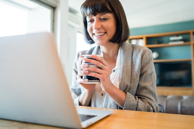 Portrait of a woman working at home and having a video call with laptop