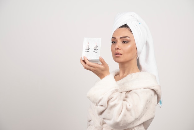 Portrait of woman wrapped in white towel with eye shadow palette