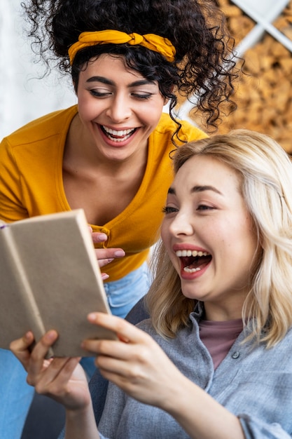 Portrait of women laughing while reading book