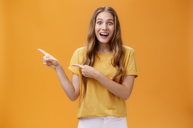 Portrait of wondered and amazed young excited girl with scar on arm and wavy hair open mouth in enth...