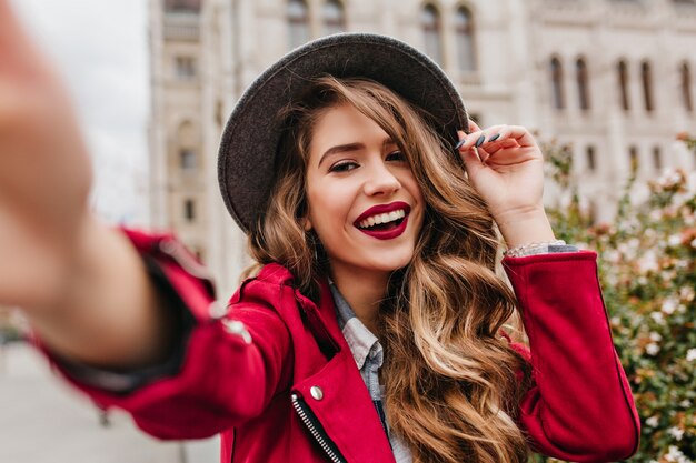 Portrait of wonderful white female model with bright makeup expressing energy in good day in Europe