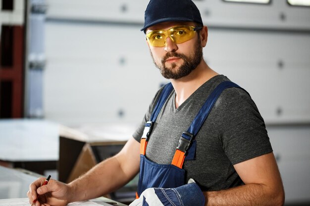 Portrait of worker in onalls, industrial steel factory.