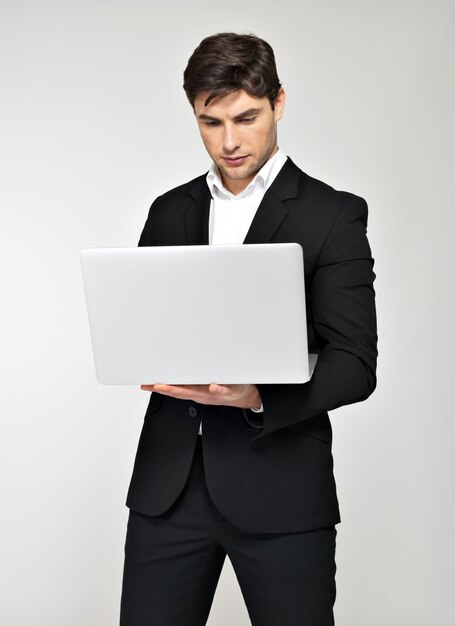 Portrait of working businessman on laptop and looking in screen