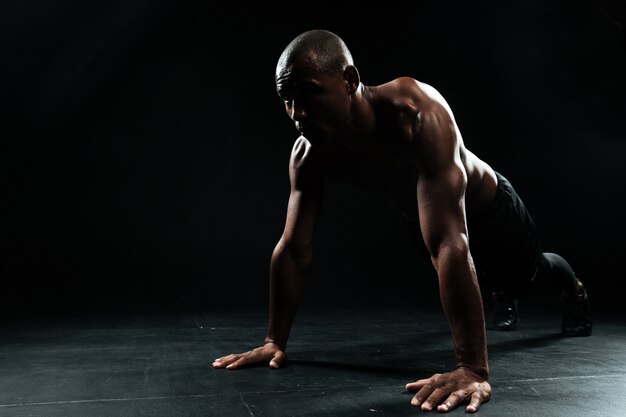 Портрет человека афро-американского спорта делает упражнение отжимания