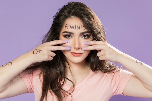 Free photo portrait of young activist painting her face