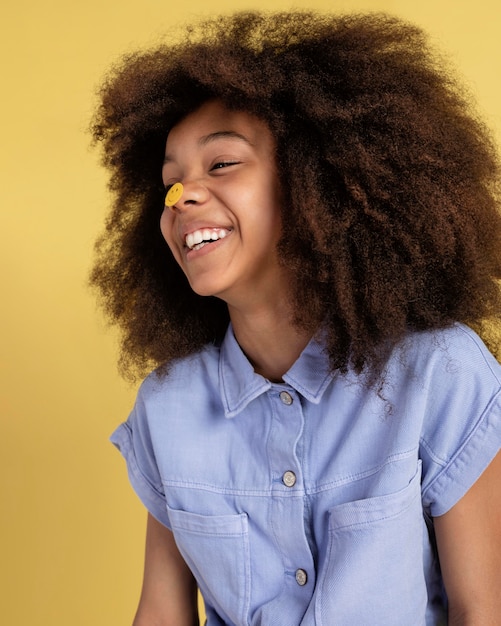 Portrait of young adorable girl posing with emoji stickers on her face