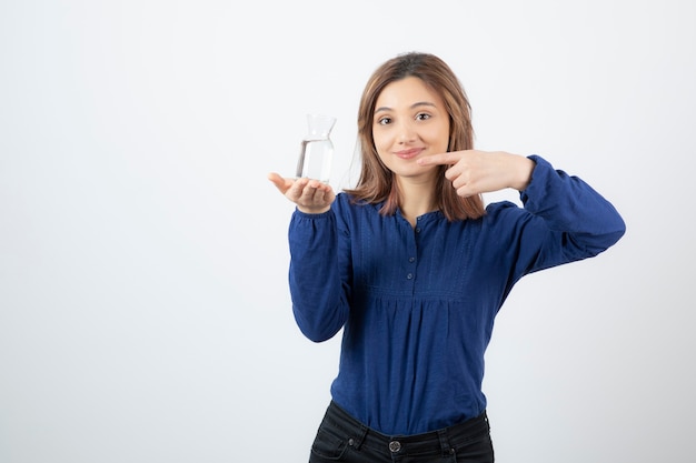 Portrait of young adorable woman holding glass of water on white background. 