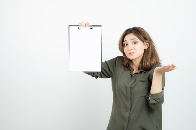 Portrait of young adorable woman showing blank clipboard. High quality photo