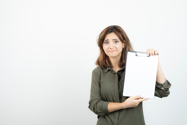Portrait of young adorable woman showing blank clipboard. High quality photo