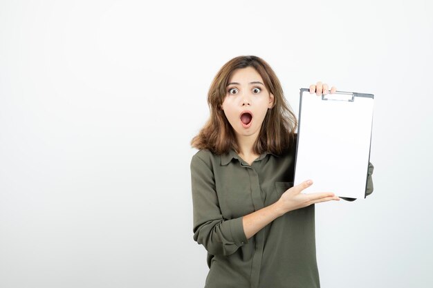 Portrait of young adorable woman showing blank clipboard. High quality photo