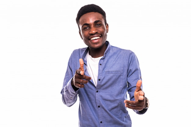 Portrait of young african-american man pointing at you and smiling, over white wall