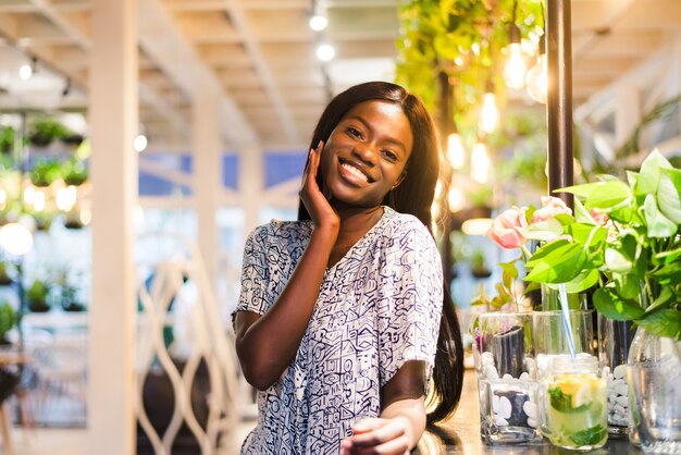 Portrait of young african woman standing in cafe